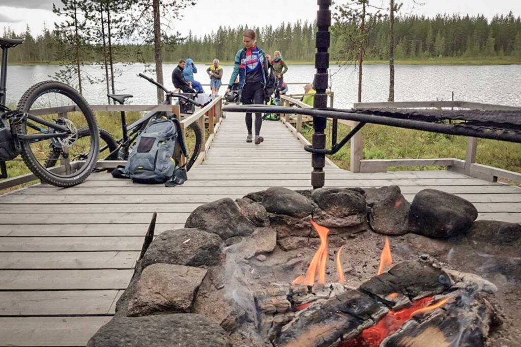 E-Biker am See beim Lagerfeuer in Finnland