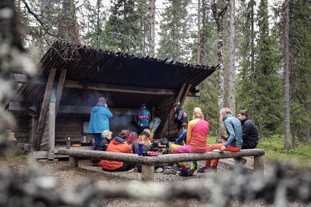 Gruppe von E-Bikern in Finnland am Lagerfeuer