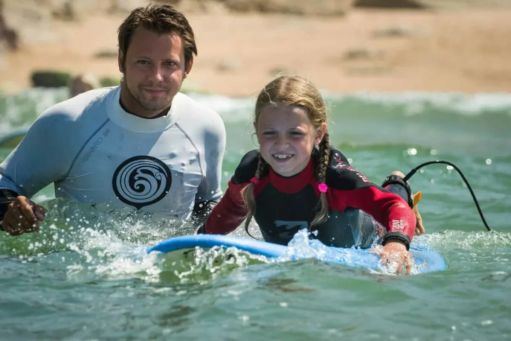 Surf instructor with young surf student