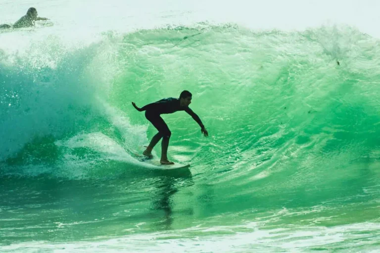 Surfer im portugiesischen Meer mit Surfbrett