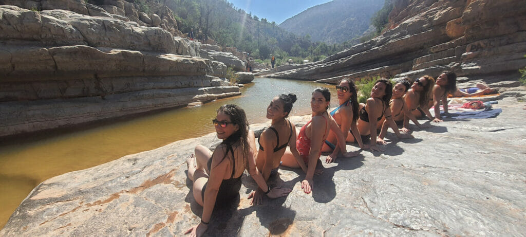 Group of women on rocks in front of a river, Wadi, Morocco